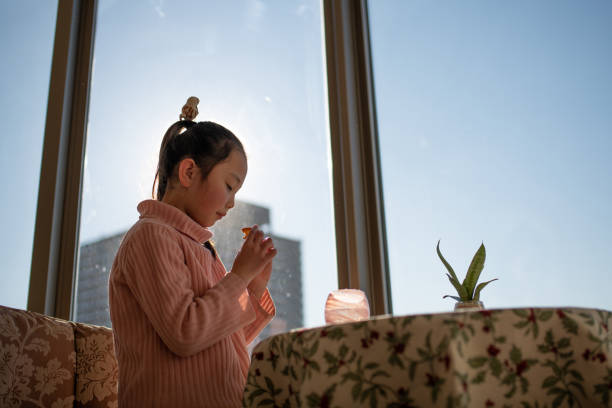 girl eating a snack at the window - eating child cracker asia imagens e fotografias de stock