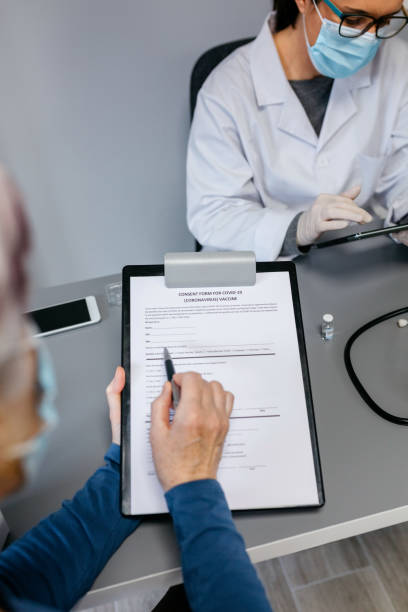 istock Woman reading consent form for coronavirus vaccine 1292579501