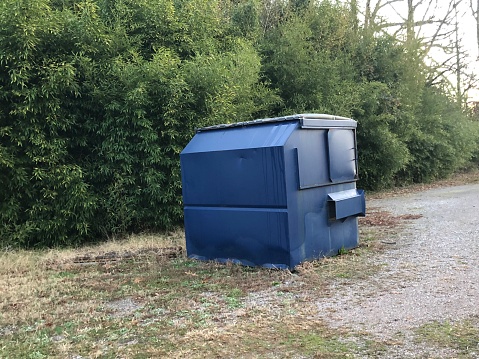 A dumpster or a skip in a field