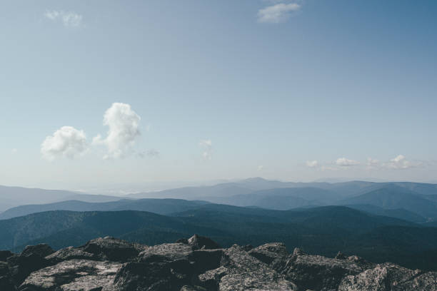 Thick clouds over mountain range, hills in blue haze