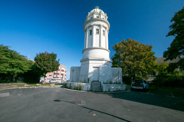Listed as Grade II in 1952, and owned by the Brighton city council, this beautiful building is today deserted and has no use other than a historical curiosity. Located in Queen's Park area, it was designed and built in 1830 by architect Charles Barry in what was once the estate for the villa of the owner of Queen's Park. Its many uses over the centuries have been as a printing house for the Brighton Daily Mail; a lookout tower in World War 2; a scout headquarters; an artist’s studio, and - in a final humiliation - as public toilets. A car is recognisable next to the monument.
