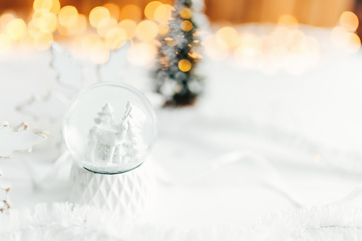 White christmas snow globe on a table with christmas decorations