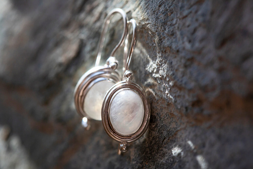 pair of sterling silver moon stone mineral earrings on natural background