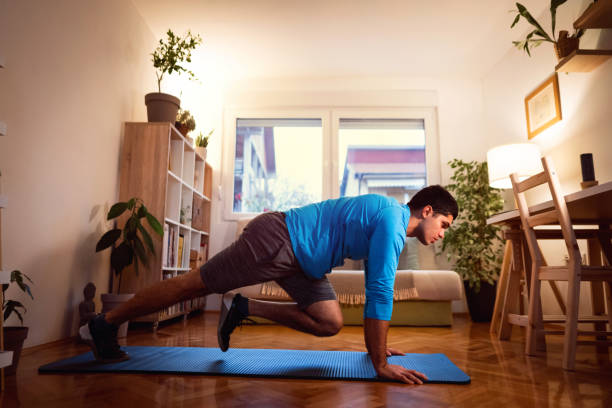 istock Young man doing mountain climbers at home 1292591468