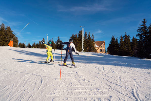 istock Ski instructor teaching female skier how to make turns  at a ski slope 1292592343