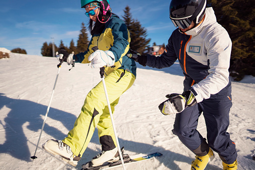 young family skiing doing the first ski lessons for the kids on carving skis