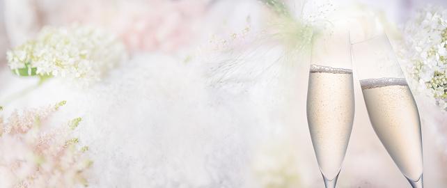 Abstract bright spring background with champagne. Blurred delicate spring blossoms for a wedding background. Horizontal close-up with short depth of field and space for text.