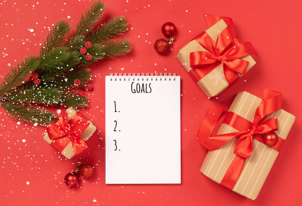 istock Christmas gifts boxes notepad with text Goals on red background New Year concept 1292594760
