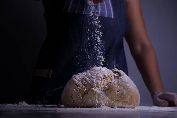 istock Woman spreading flour over a big bread 1292595073