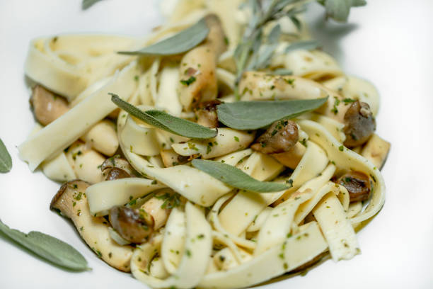 Handmade spaghetti with sage, herb mushrooms and garlic served on a pasta plate