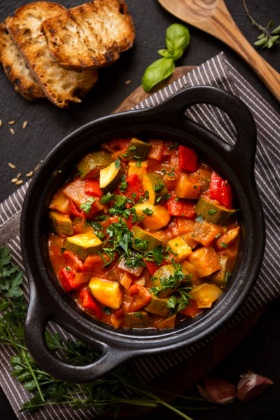 istock Cooked various chopped vegetables with herbs in a black cooking pot 1292597374