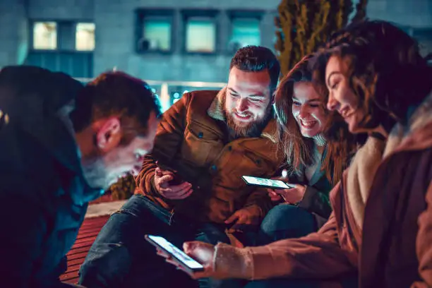 Photo of Friends Spending Time With Smartphones Outside