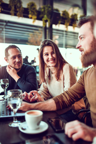 istock Friends Enjoying Coffee Time Together And Using Laptop In Restaurant 1292597488