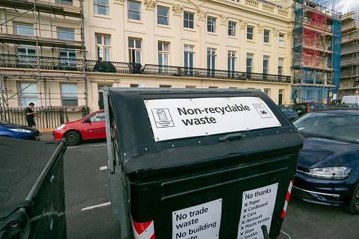 Non-recyclable Waste Bin in Brighton, England, with people and cars in the background