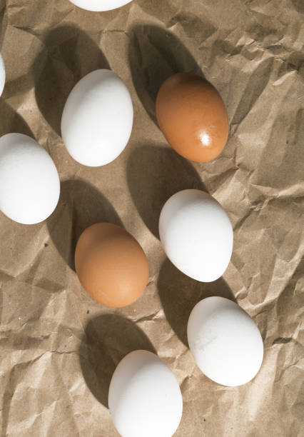 istock Brown and White fresh eggs on a paper. Top view 1292599906