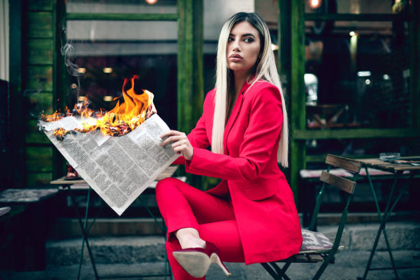 istock Elegant Female Reading Burning Newspaper 1292601084