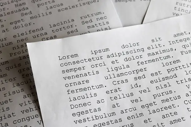 Photo of lorem ipsum dolor sit amet concept. selective focus photo of paper sheets with publishing and graphic design placeholder text on them.