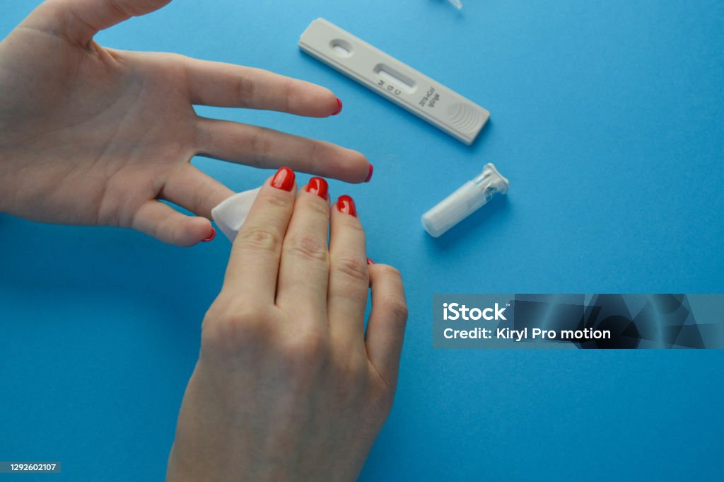 Hands of a nurse with individual protection equipment and patient, in the process of blood collection to make a rapid test for covid-19(coronavirus), in a hospital ward with sanitary elements Hands of a nurse with individual protection equipment and patient, in the process of blood collection to make a rapid test for covid-19(coronavirus), in a hospital ward with sanitary elements. Analyzing Stock Photo