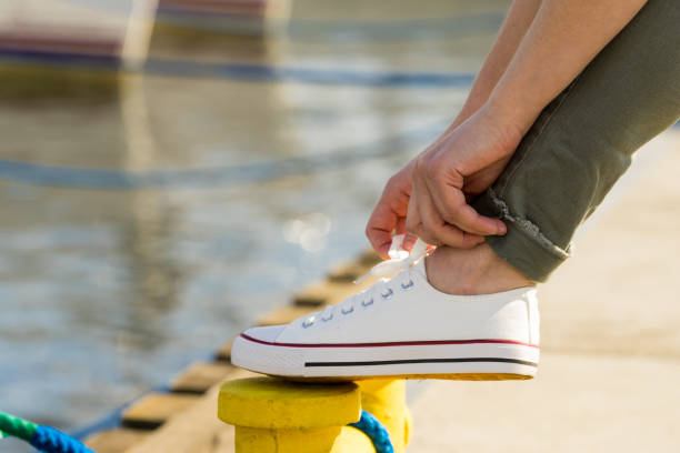istock Woman tying shoes, white sneakers 1292602221