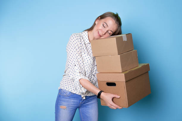 istock Accept a parcel, happy young woman holding a stack of cardboard boxes, 1292605502