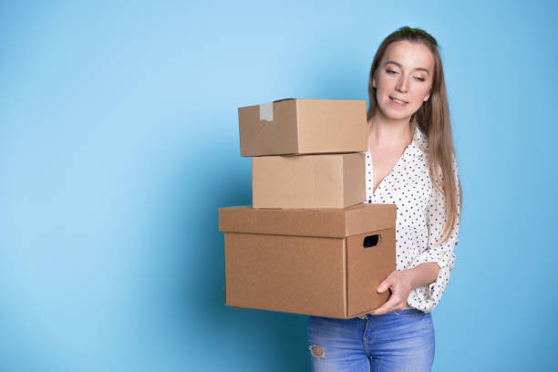istock Accept a parcel, happy young woman holding a stack of cardboard boxes, 1292605508