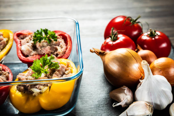 Uncooked stuffed pepper with minced-meat and rice on wooden table