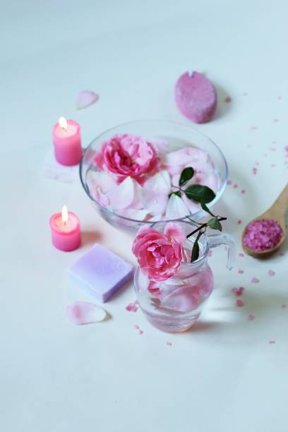 istock Fresh pink roses, water, petals, candles on a light background 1292612454
