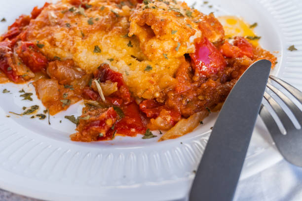istock Cod with red peppers, tomato and onion on a white plate 1292613822