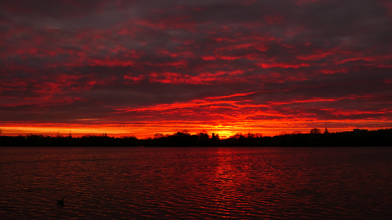 Dramatic red sky on the horizon with water on the foreground.