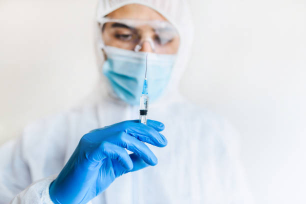 médico/ médico segurando uma seringa com vacina na mão. conceito de vacinação coronavírus. - genetic research men chemical protective glove - fotografias e filmes do acervo