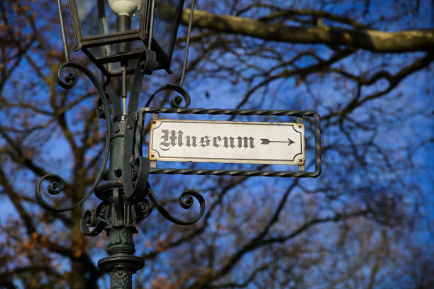 istock View on isolated direction sign with word museum in old german scripture on antique street lamp pole. 1292614205