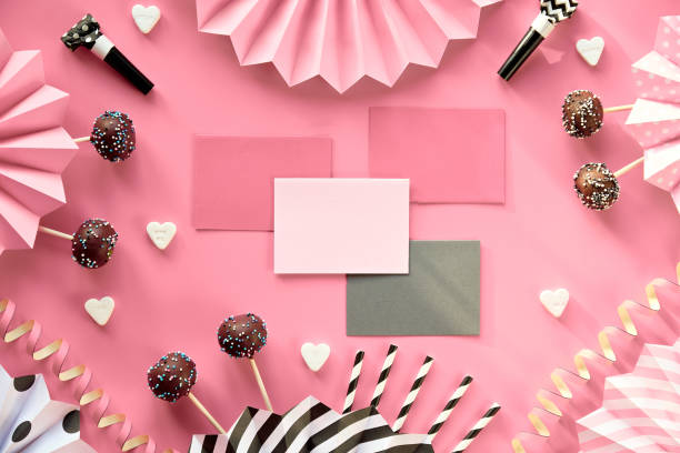 Invitation cards with copy-space. Chocolate cake pops decorated with colored sugar icing. Creative monochrome top view on pink paper with folded paper fans, confetti, sugar hearts, drink straws tarjetas de invitación con espacio de copia. pastel de chocolate decorado con glaseado de azúcar de colores. creativo monocromo plano yacía sobre papel rosa con ventiladores de papel doblados, confeti, corazones de azúcar, pajitas de bebida