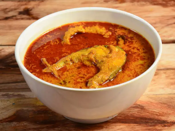 spicy and hot king fish curry, Kerala India. Barracuda Fish curry with green chili, coconut milk and mango Asian cuisine.. served over a rustic wooden background,selective focus