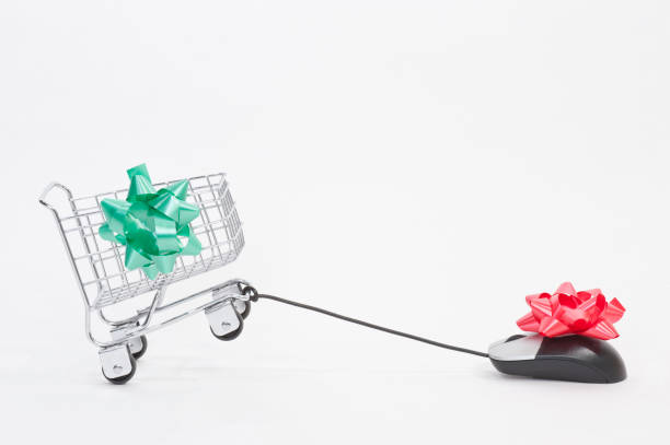 Christmas shopping retail store verses online shopping cart with Christmas bow in tug of war with mouse with Christmas bow verses stock pictures, royalty-free photos & images