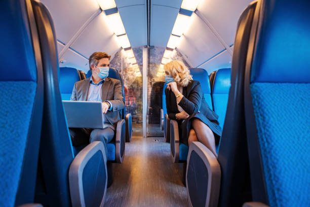 corona praktijken voor een forenzentrein reiziger business paar - trein nederland stockfoto's en -beelden