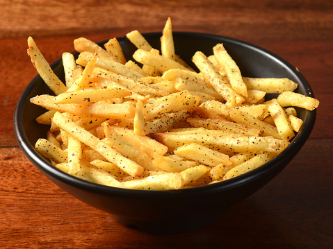 Mix herb French fries, served in a plate over a rustic wooden background, indian cusine, selective focus
