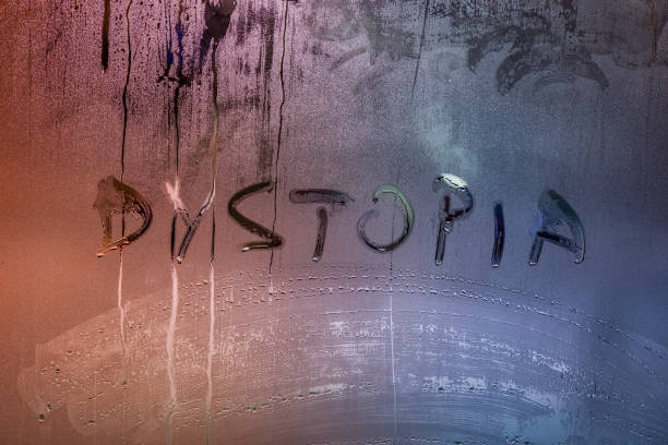 the word dystopia handwritten on wet window glass surface the word dystopia handwritten on wet window glass surface close-up with selective focus and color gradient dystopia concept photos stock pictures, royalty-free photos & images