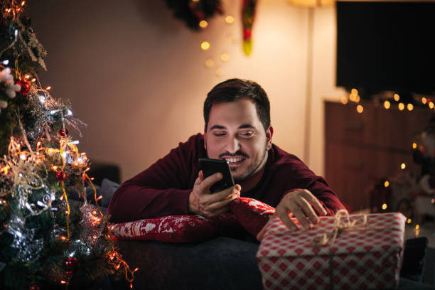 istock Young happy man using phone on New Year's eve at home 1292621753
