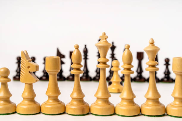 istock Rows of chess pieces stand opposite each other on a white background 1292621869