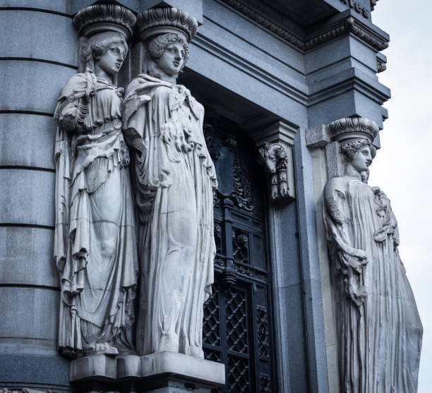 Caryatids sculpted statues of figures of women at Instituto Cervantes entrance in Madrid. Historical building in Spain capital. Neoclassic architectonic style, cold blue effect applied