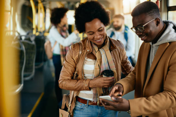 istock Happy black couple using smart phone while traveling by bus. 1292624893