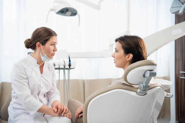 istock A young woman explaining her dental problem to her doctor, the d 1292625824