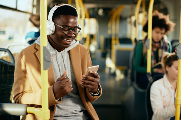 istock Young black man having fun while using smart phone and listening music in a public transport. 1292626152