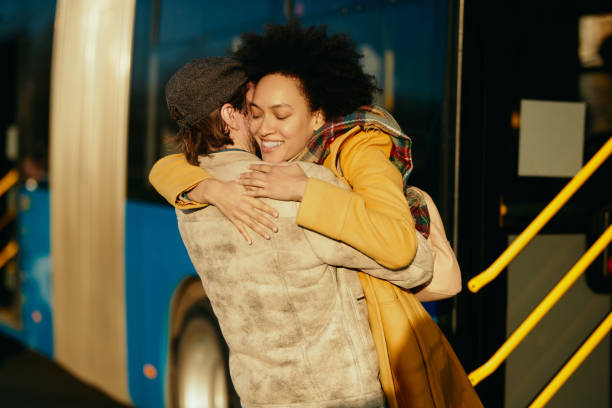 istock Affectionate couple embracing while meeting at bus station. 1292626737