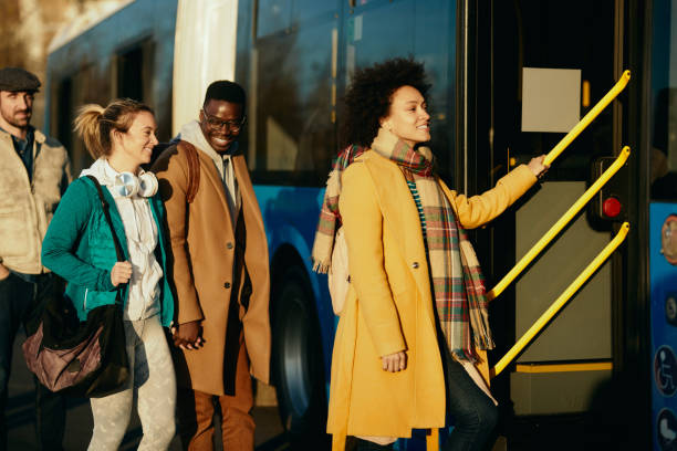 group of happy people entering a bus at the station. - bus station imagens e fotografias de stock