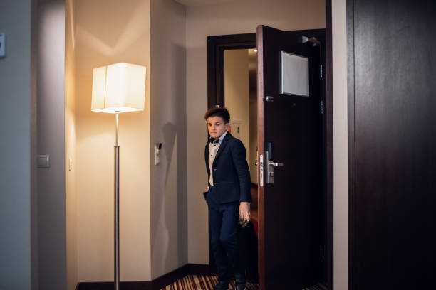 istock A young boy in formal wear entering a hotel room 1292626831