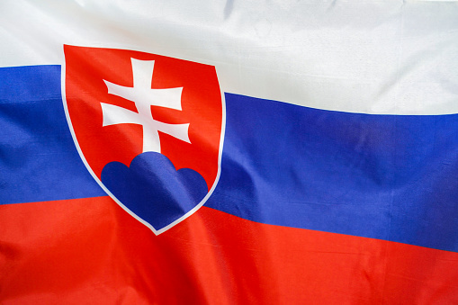 Fabric texture flag of Slovakia. Flag of Slovakia waving in the wind. Slovakia flag is depicted on a sports cloth fabric with many folds. Sport team banner