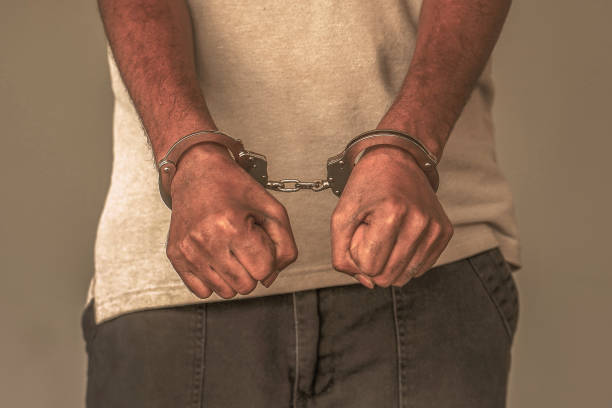 istock Criminal hands locked in handcuffs. Close-up view 1292628529