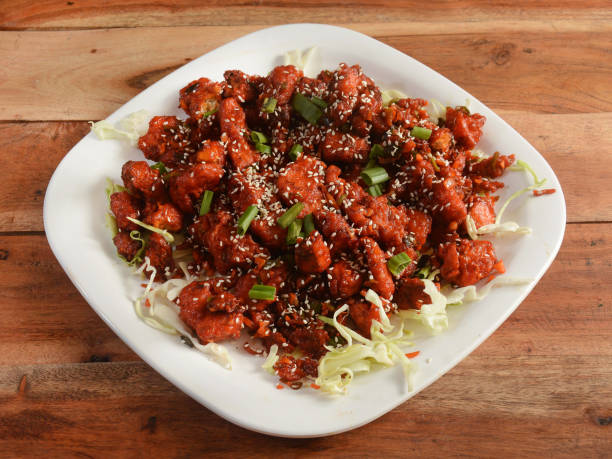 istock Crispy Paneer - crispy fried slices of cottage cheese mixed with masala, served over a rustic wooden background, selective focus 1292629751