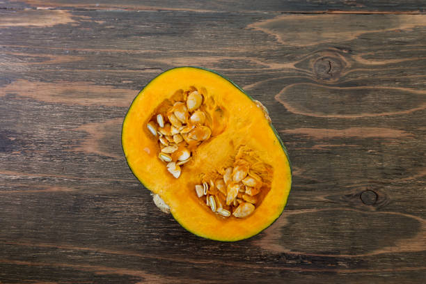 istock a pumpkin cut in half in a wooden background 1292630836
